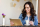 Young woman sitting indoor drinking coffee and looking at her tablet computer. Cool young modern caucasian female in her 20s. Cafe city lifestyle.